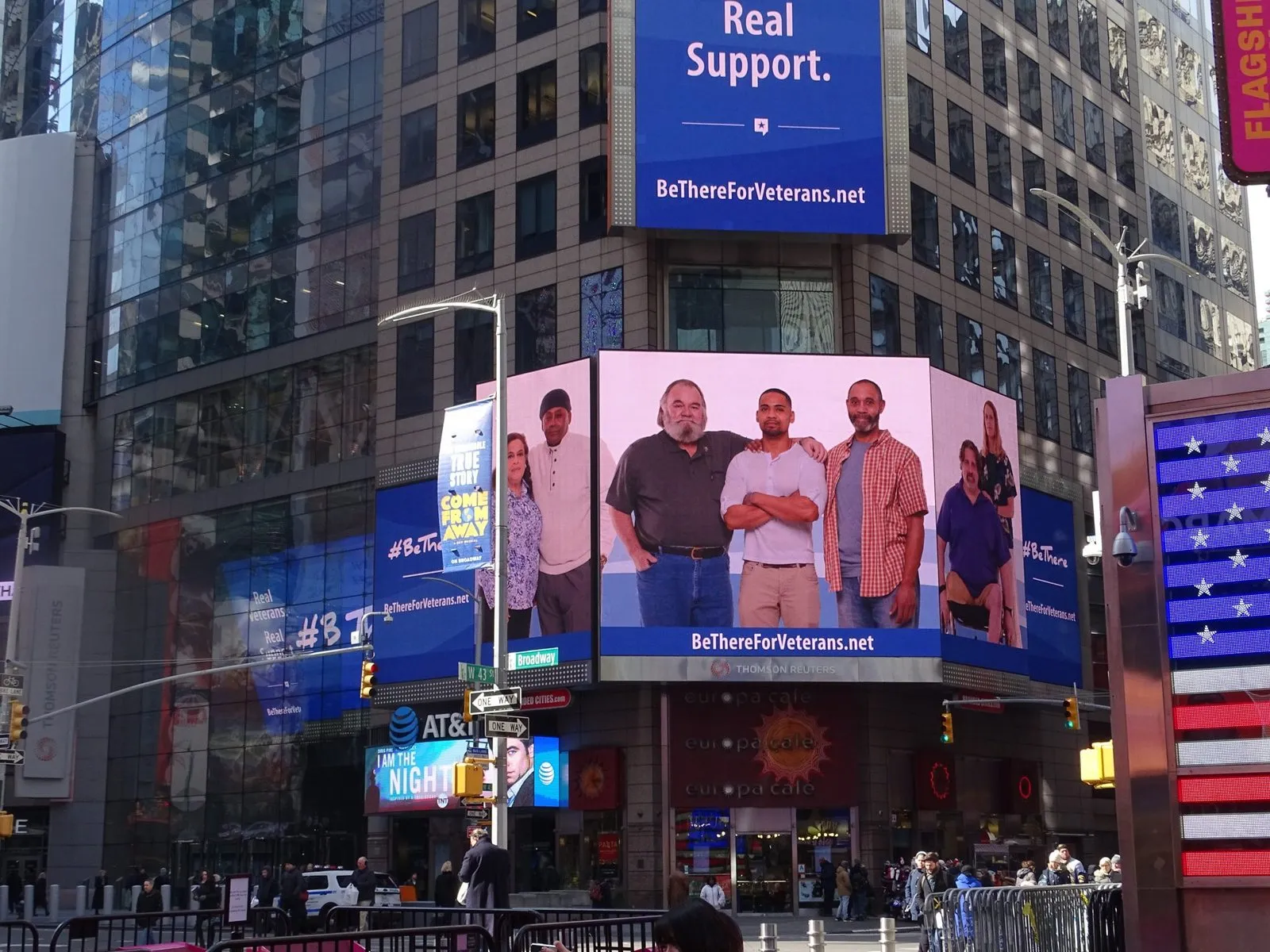 A wide Times Square screen carrying the campaign's “Real Support.” message over photographs of Veterans.